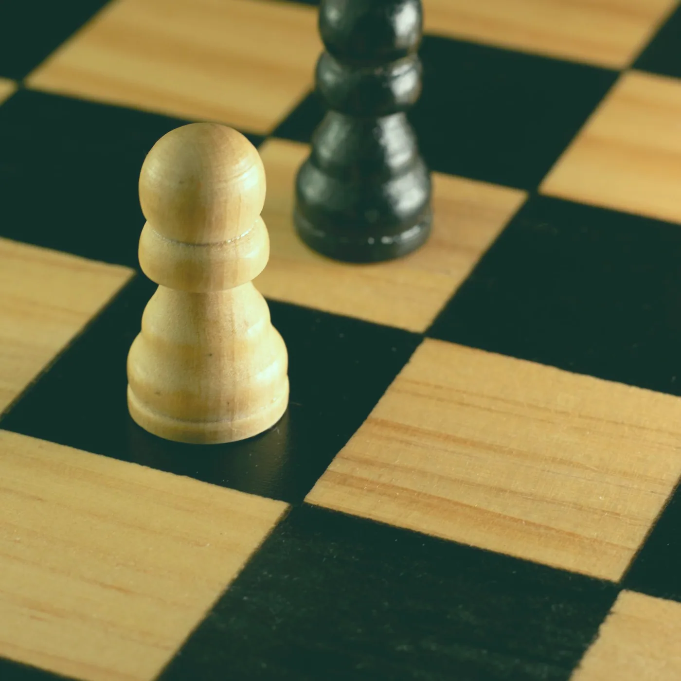 Hands moving wooden pieces across a game board while others look on